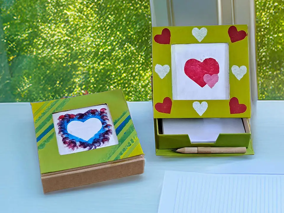 Individuell bemalte Notizbox mit farbigen Mustern, Notizzetteln und Bleistift