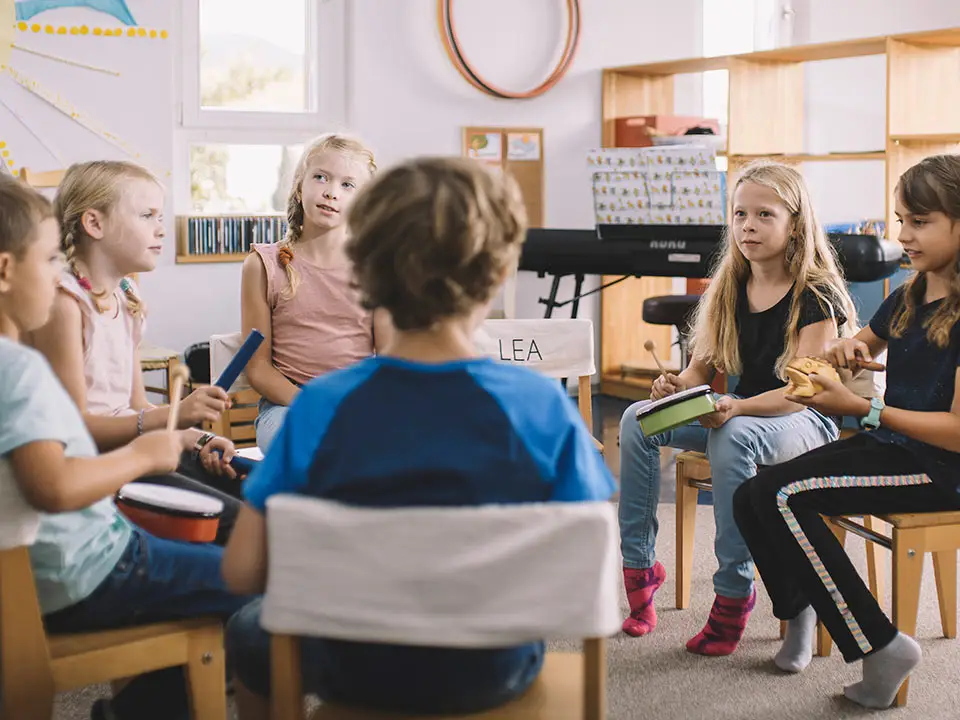 Kinder im Sitzkreis am Musizieren